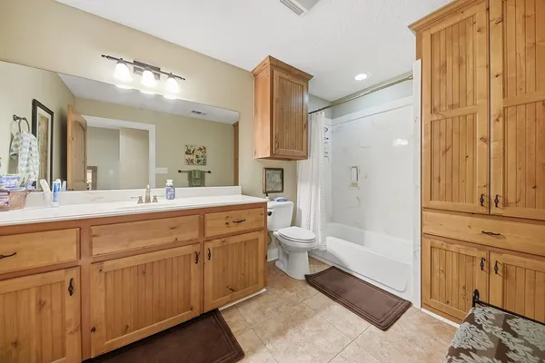 a spacious bathroom with a double vanity sink a mirror and a bathtub