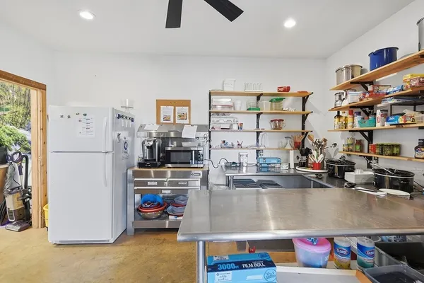 a living room with lots of furniture and a refrigerator