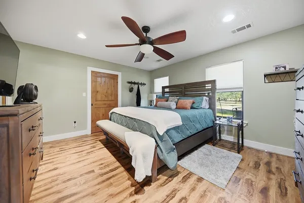 a bedroom with a large bed and a chandelier
