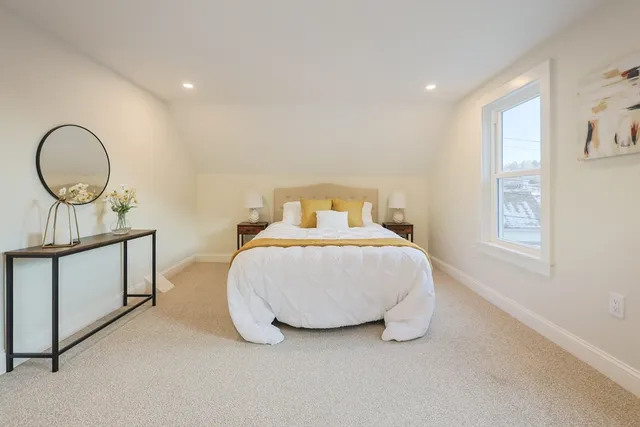 a bedroom with a bed lamp and a window
