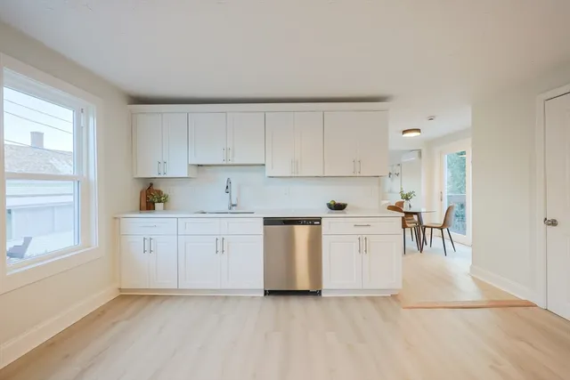 a kitchen with granite countertop white cabinets and white appliances