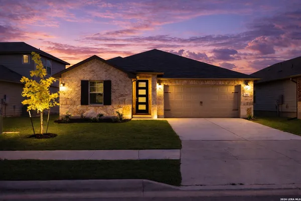 a front view of a house with a yard and a garage