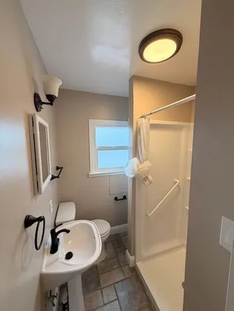 a bathroom with a sink a toilet and shower