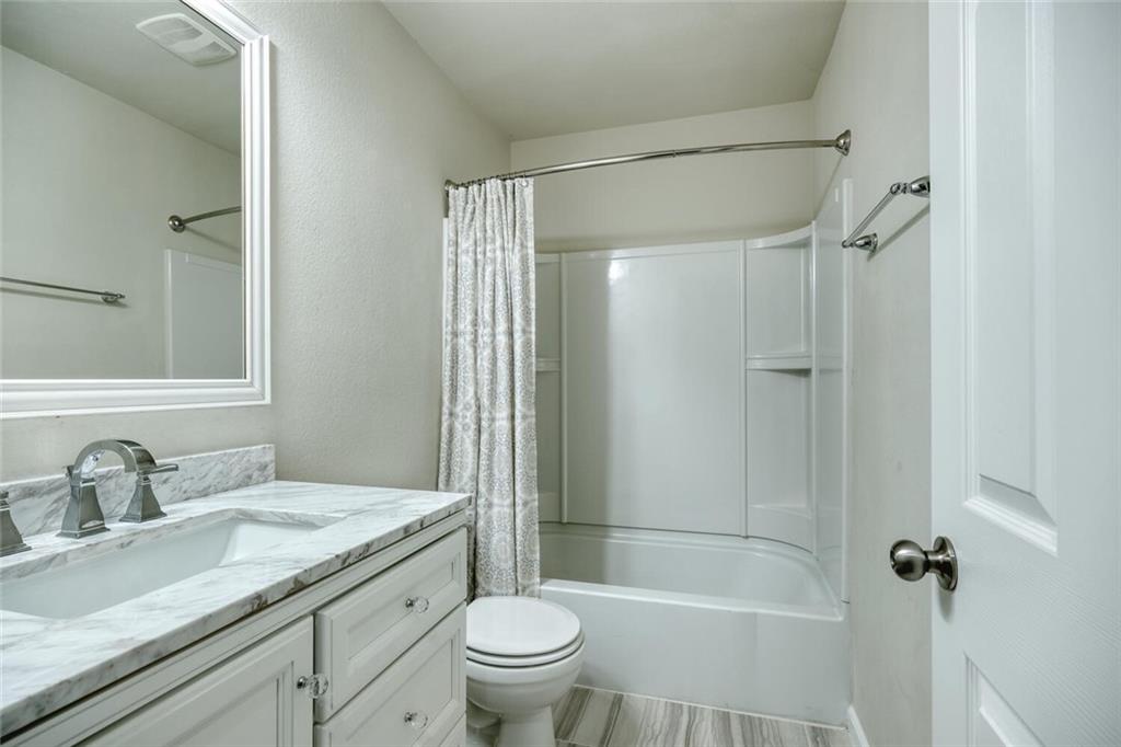 10053 Aly May Drive Austin, TX 78748 - Photo 12 of 15 a bathroom with a granite countertop sink a toilet and shower