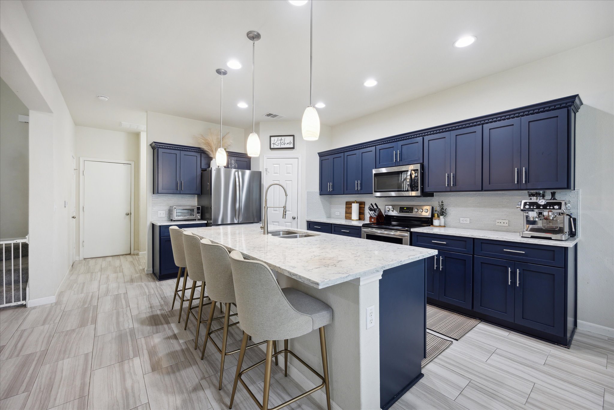 10053 Aly May Drive Austin, TX 78748 - Photo 7 of 15 a kitchen with kitchen island granite countertop wooden floors wooden cabinets a center island and stainless steel appliances