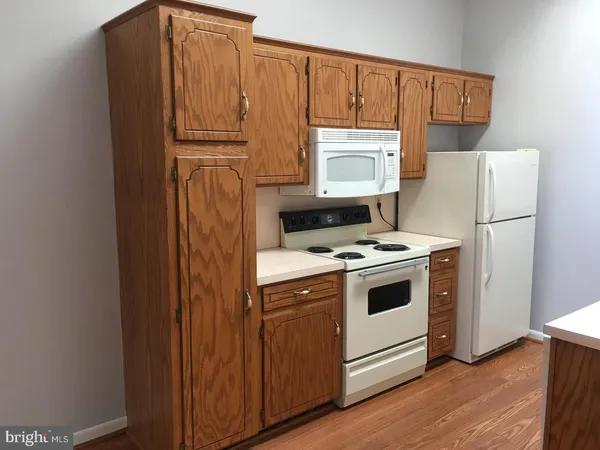 a kitchen with a refrigerator stove and wooden cabinets