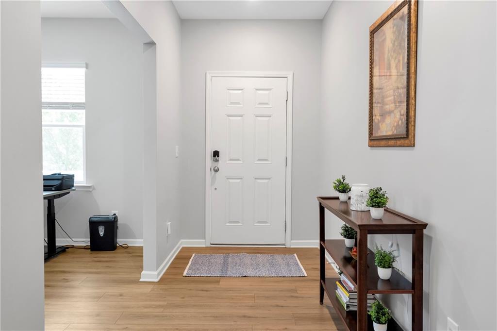 660 Groover Street Ball Ground, GA 30107 - Photo 5 of 53 a view of a hallway with wooden floor and a workspace