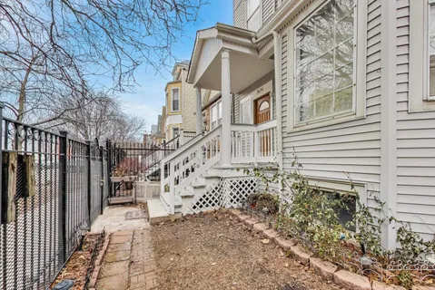 a view of a house with a small yard and wooden fence