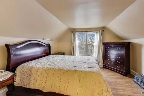 a bedroom with a bed and a flat tv screen on wall