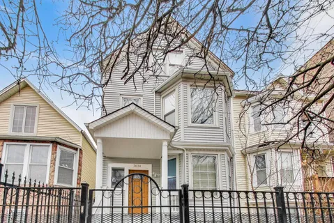 a front view of a house with a tree