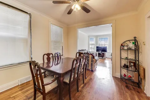 a view of a a dining room and livingroom with furniture wooden floor a chandelier