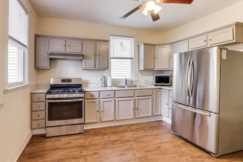 a kitchen with stainless steel appliances a refrigerator sink and microwave