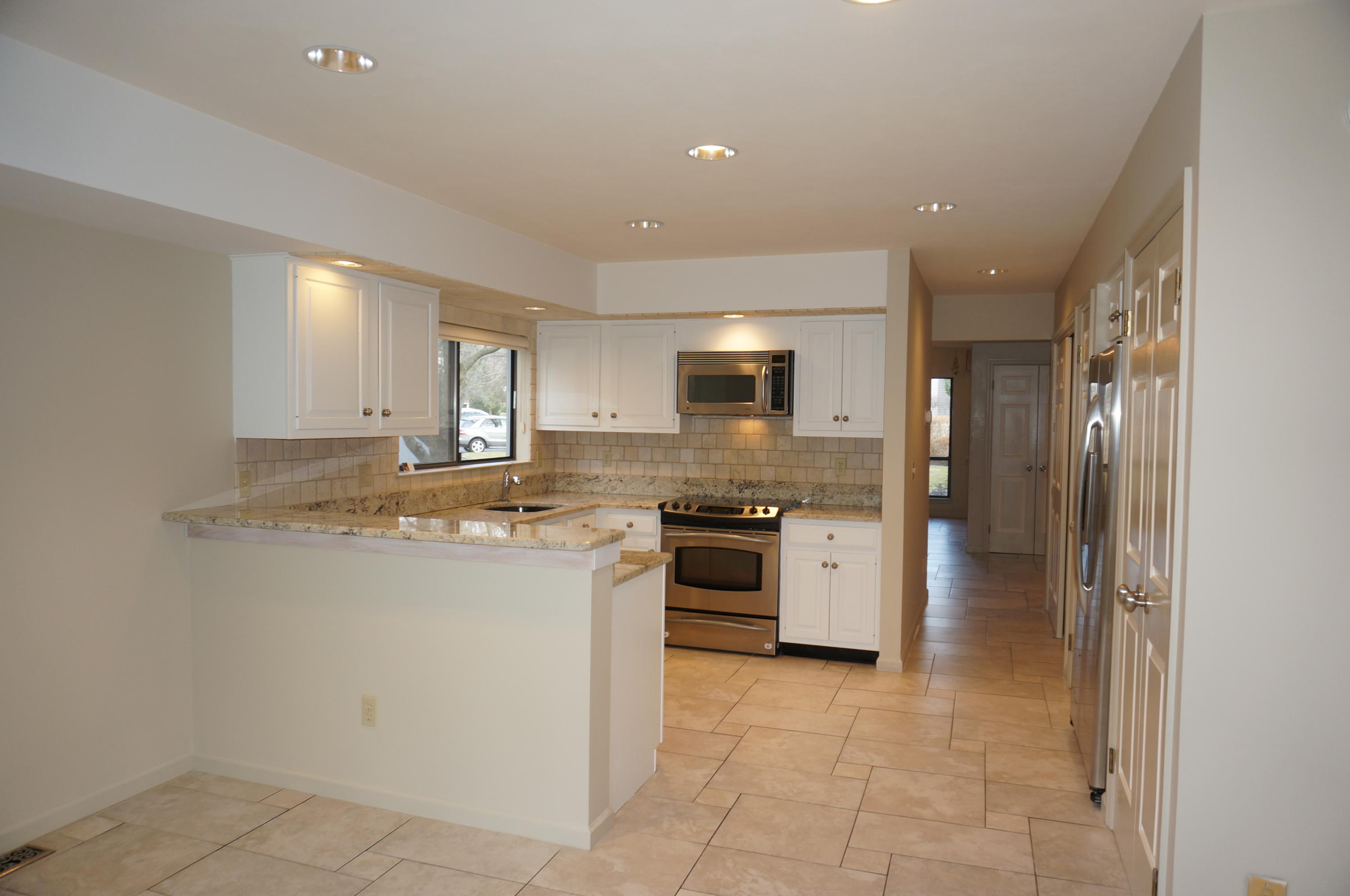 500 River Road, Unit 7 Greenwich, CT 06807 - Photo 8 of 29 a kitchen with stainless steel appliances granite countertop a refrigerator and a stove