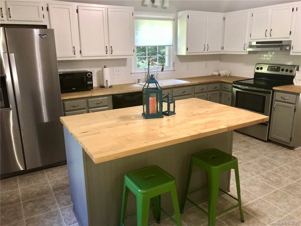 708 Trail Ridge Road Matthews, NC 28105 - Photo 24 of 40 a kitchen with granite countertop a refrigerator a stove a sink and white cabinets