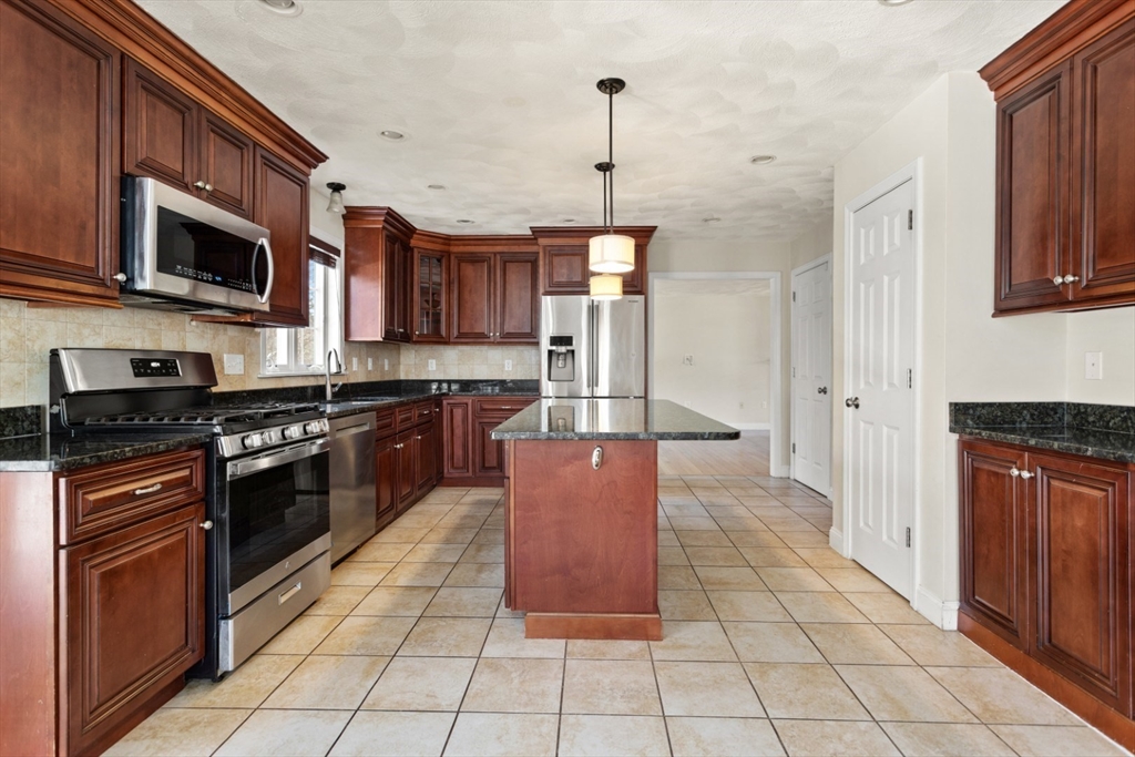 3 Gordon Road North Reading, MA 01864 - Photo 14 of 38 a kitchen with stainless steel appliances granite countertop a stove a sink and a microwave