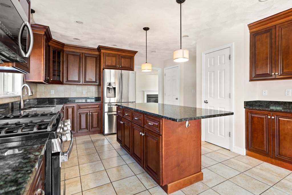 3 Gordon Road North Reading, MA 01864 - Photo 15 of 38 a kitchen with stainless steel appliances granite countertop a stove a sink and a refrigerator
