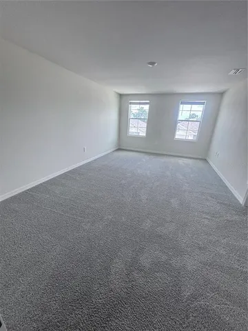a view of a big room with windows and chandelier fan