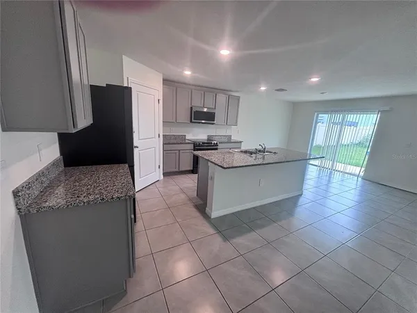 a kitchen with stainless steel appliances granite countertop a sink and a refrigerator