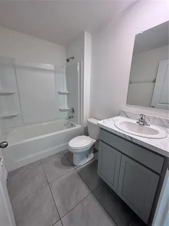 a bathroom with a granite countertop sink toilet a mirror and bathtub