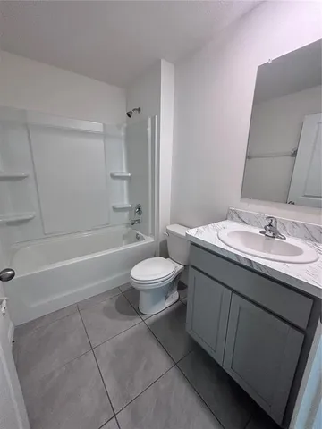 a bathroom with a granite countertop sink toilet a mirror and bathtub