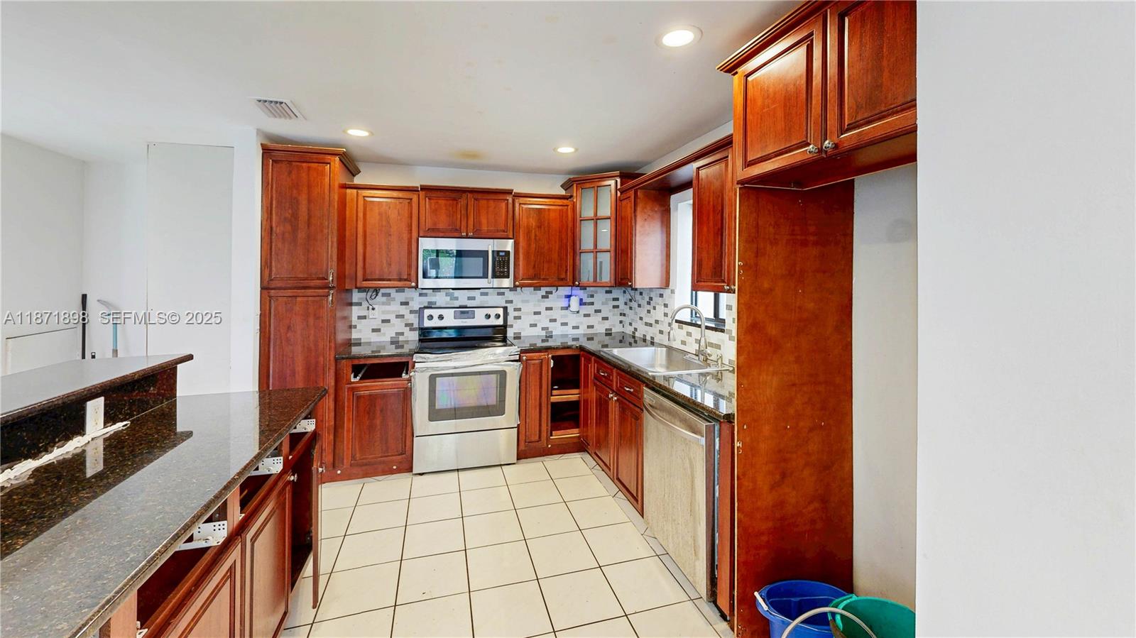 15166 Southwest 94th Terrace Miami, FL 33196 - Photo 24 of 83 a kitchen with stainless steel appliances granite countertop a stove a sink and a microwave