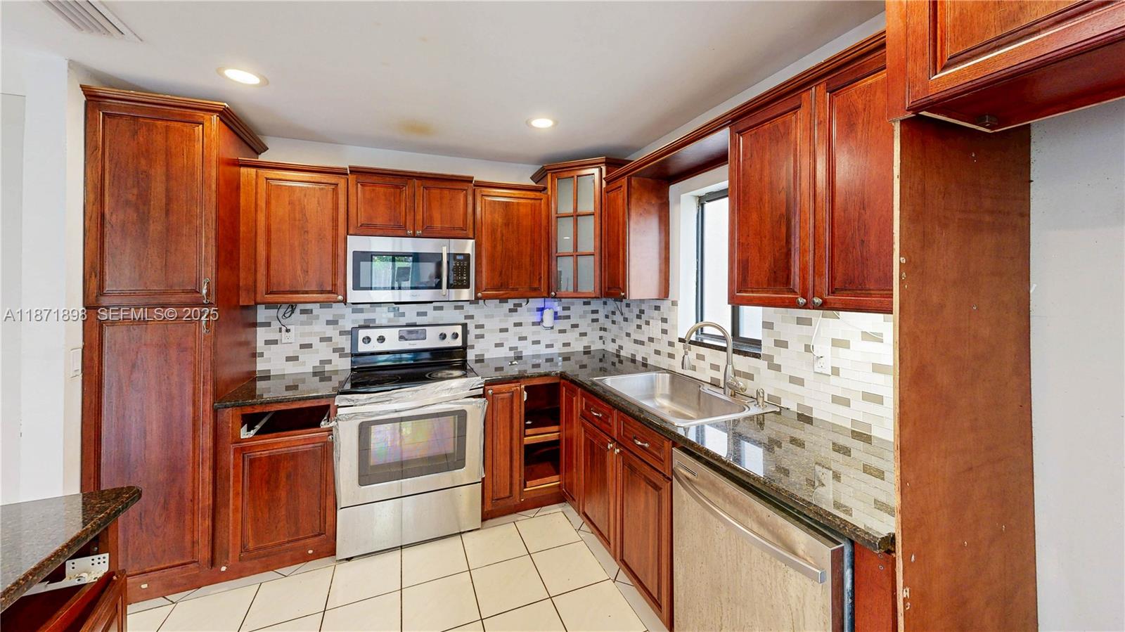 15166 Southwest 94th Terrace Miami, FL 33196 - Photo 25 of 83 a kitchen with stainless steel appliances granite countertop a sink stove microwave and cabinets