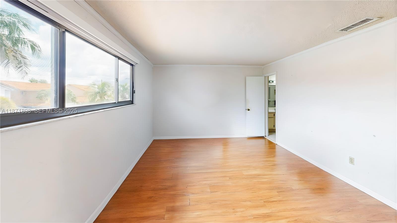 15166 Southwest 94th Terrace Miami, FL 33196 - Photo 39 of 83 a view of an empty room with wooden floor and a window