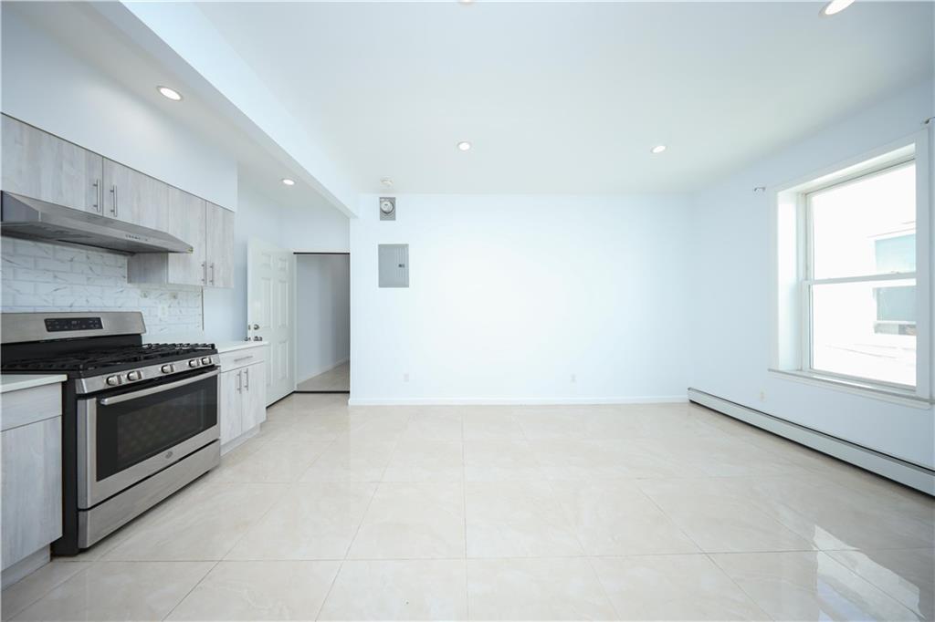 522 81 Street Brooklyn, NY 11209 - Photo 21 of 42 an empty room with a fireplace and windows