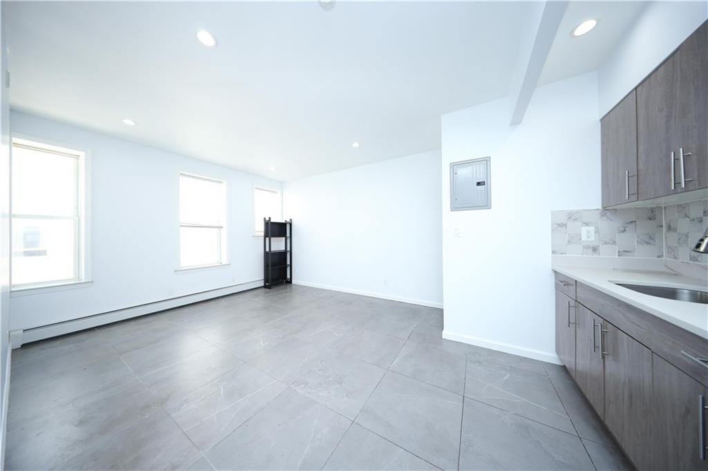 522 81 Street Brooklyn, NY 11209 - Photo 7 of 42 an empty room with cabinet and windows