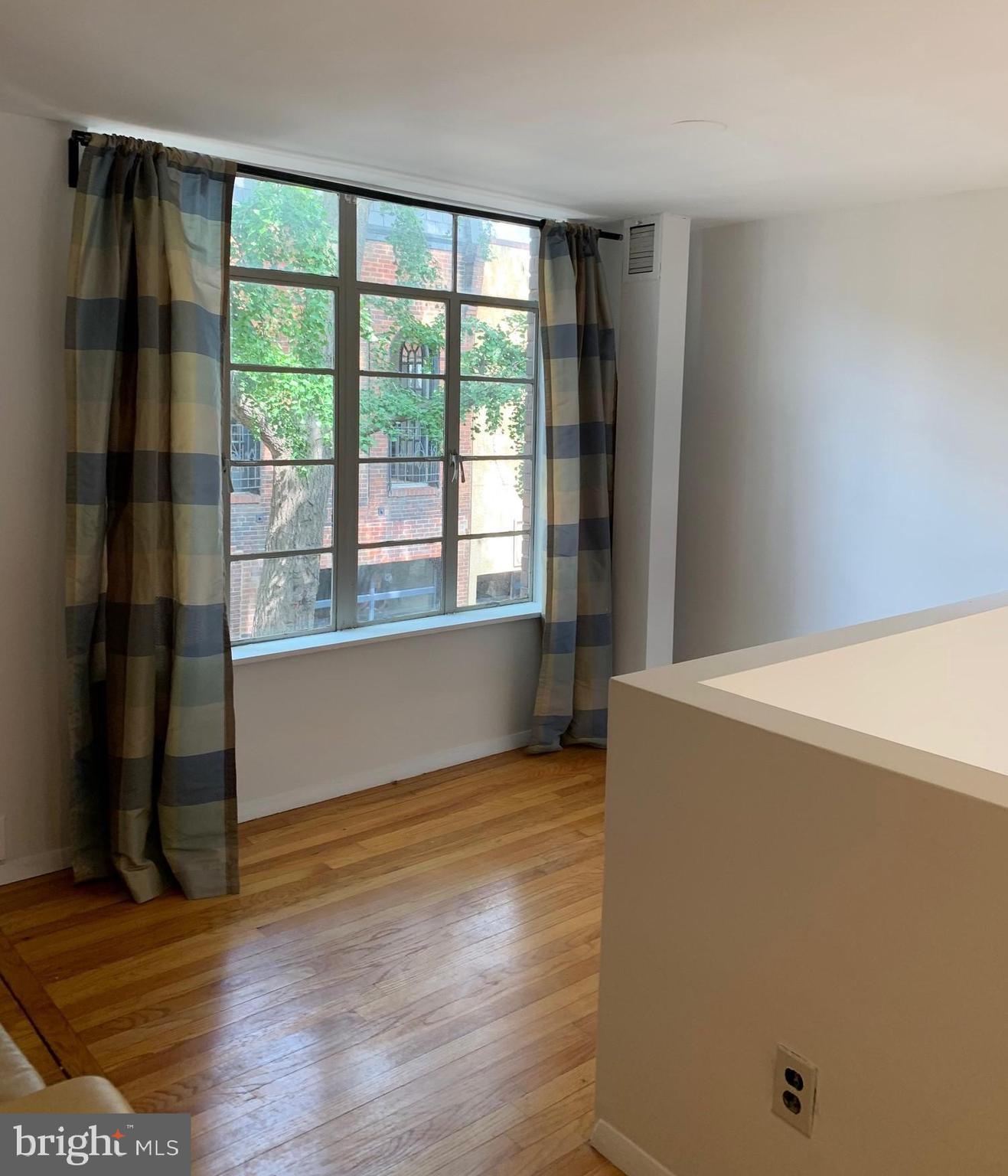 2018 Waverly Street Philadelphia, PA 19146 - Photo 13 of 22 a view of an empty room with wooden floor and a window