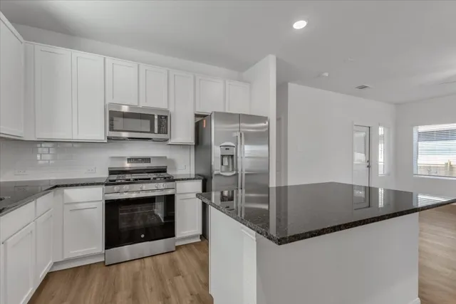 a kitchen with stainless steel appliances granite countertop a sink and a stove