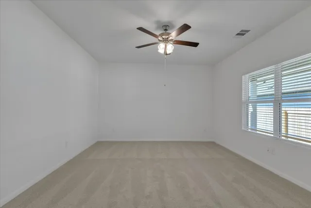an empty room with a window and a fan