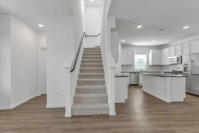 a kitchen with white cabinets and stainless steel appliances