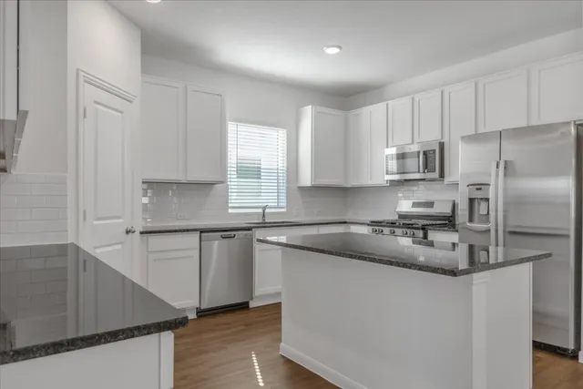 a kitchen with a refrigerator stove top oven and sink