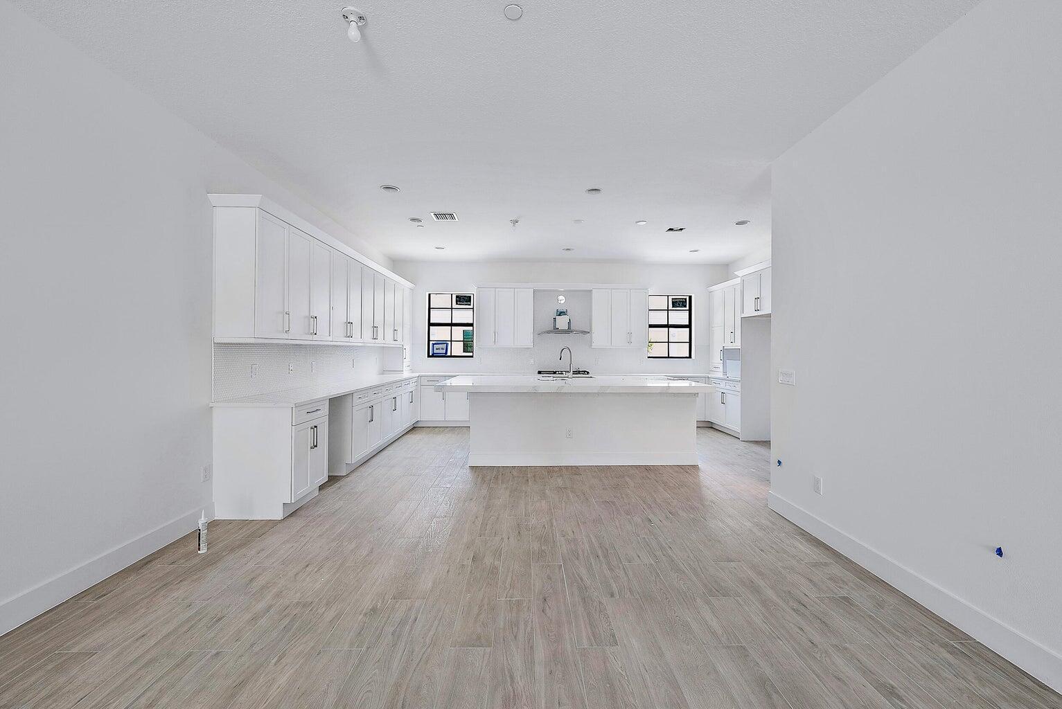 5264 Beckman Terrace Palm Beach Gardens, FL 33418 - Photo 2 of 12 a view of a kitchen with wooden floor and electronic appliances