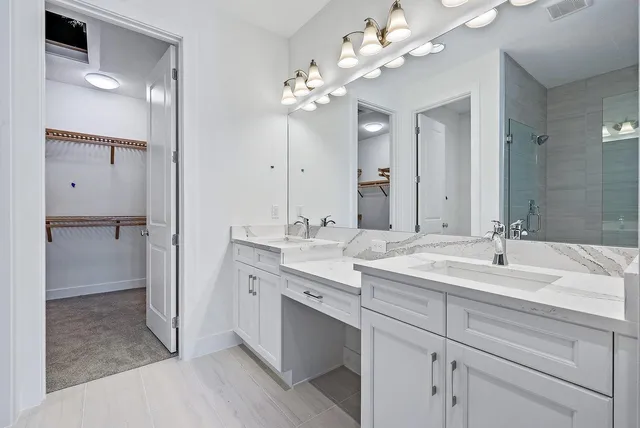 a spacious bathroom with a granite countertop sink a mirror and a shower