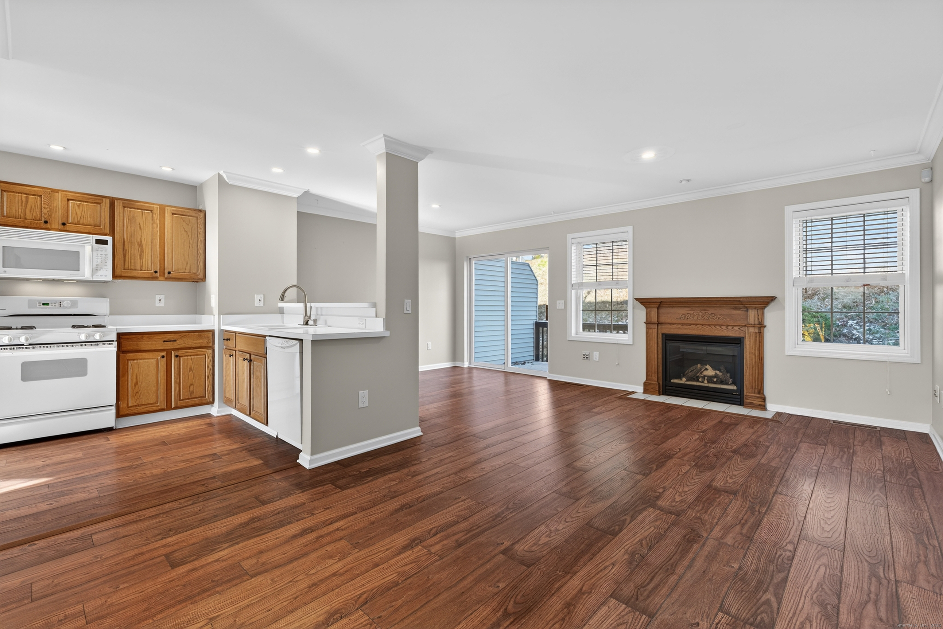1902 Revere Road, Unit 1902 Danbury, CT 06811 - Photo 3 of 37 a view of an empty room with wooden floor and a kitchen