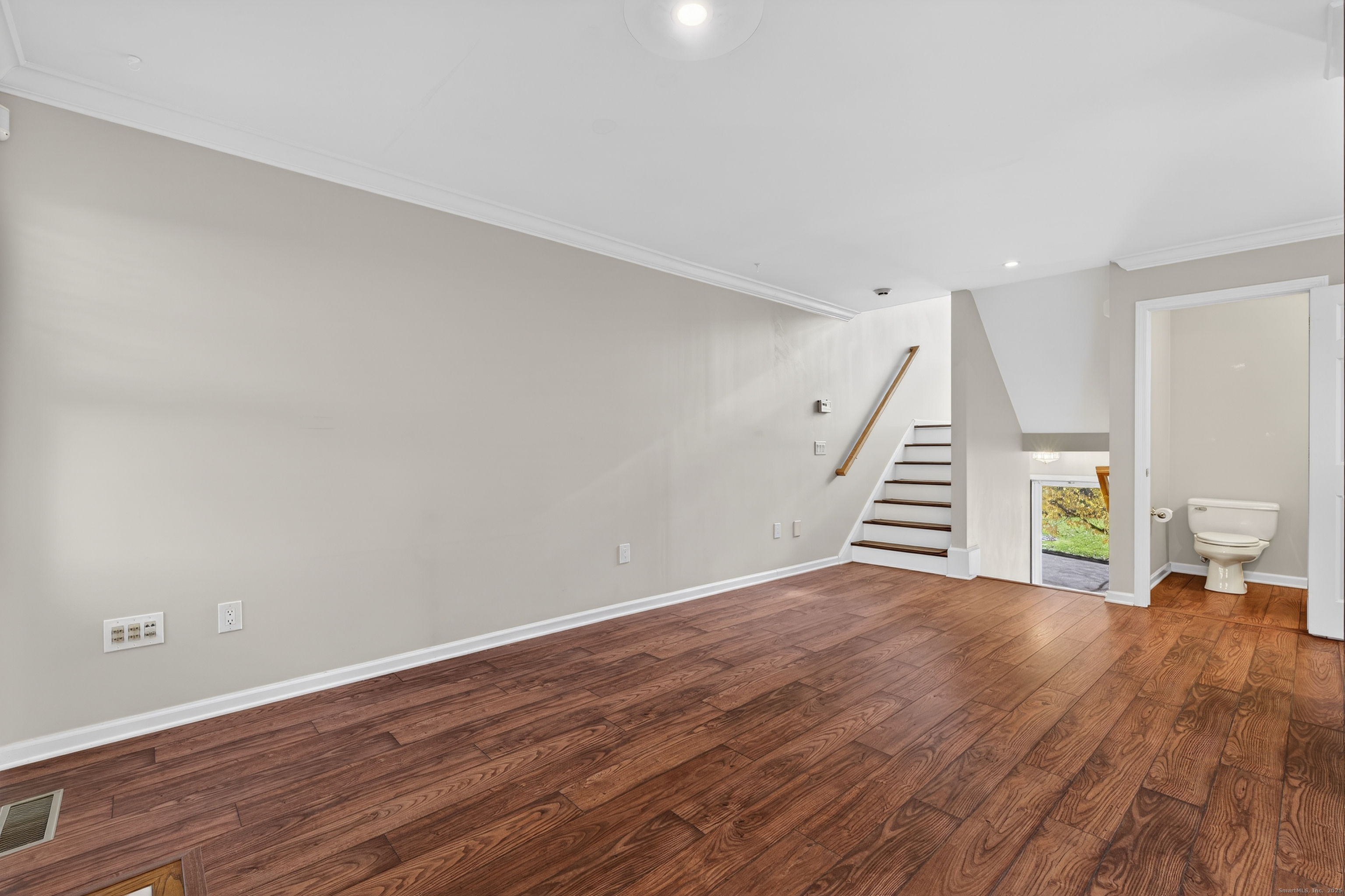 1902 Revere Road, Unit 1902 Danbury, CT 06811 - Photo 9 of 37 a view of an empty room with wooden floor and stairs