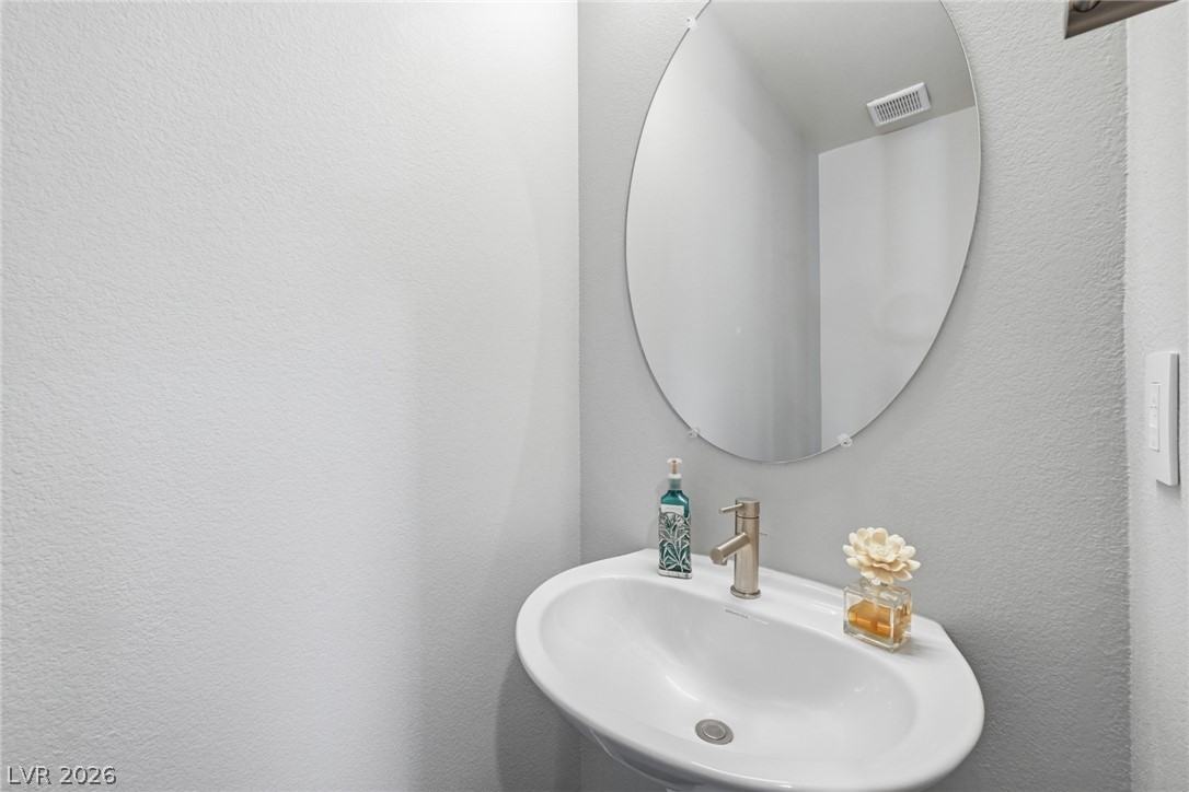4246 Swift Street Las Vegas, NV 89135 - Photo 25 of 71 Bathroom featuring a sink and a textured wall