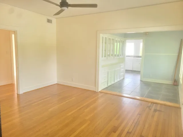 a view of an empty room with wooden floor