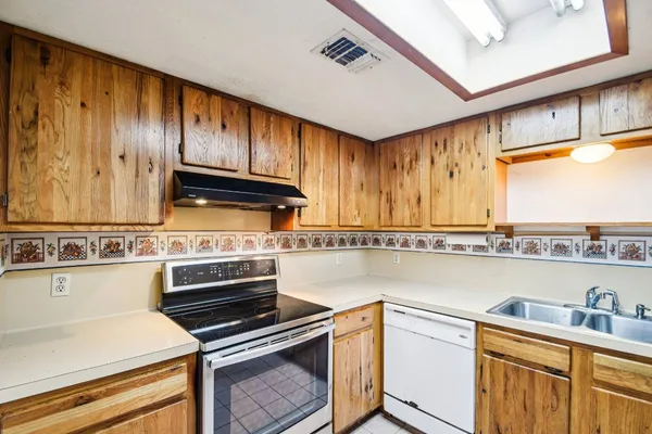 a bathroom with a granite countertop sink and a window
