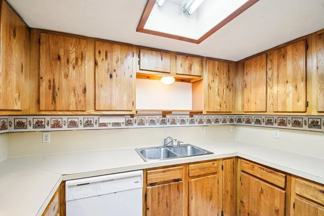 a view of a kitchen with a sink and cabinet with a flat screen tv