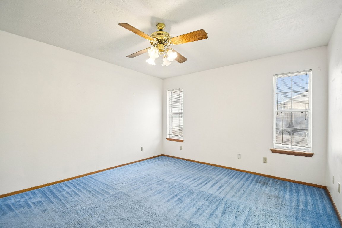 102 Stubblefield Drive Elgin, TX 78621 - Photo 16 of 39 an empty room with wooden floor fan and windows