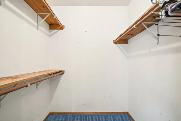 an empty room with wooden floor chandelier fan and windows