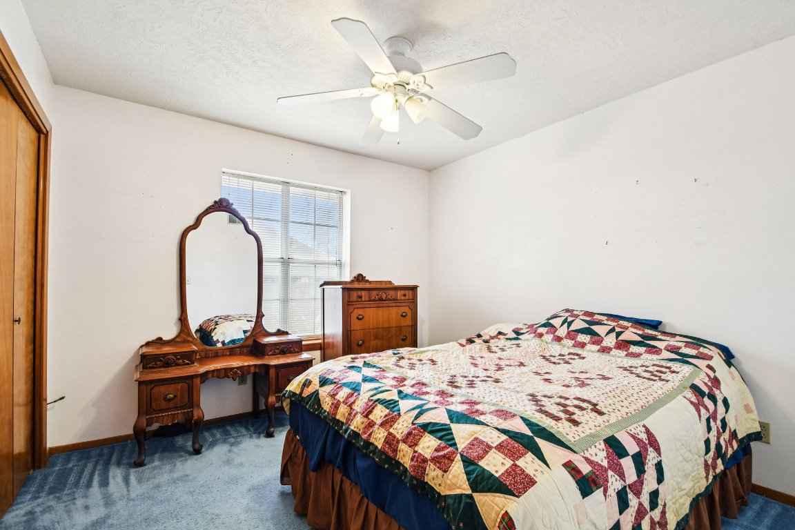 102 Stubblefield Drive Elgin, TX 78621 - Photo 24 of 39 a bedroom with a bed and a chandelier