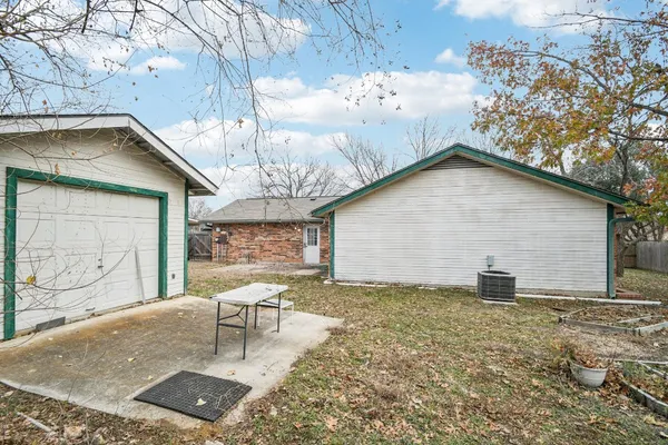 a backyard of a house with table and chairs