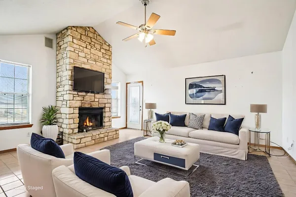 a living room with furniture a fireplace and a flat screen tv