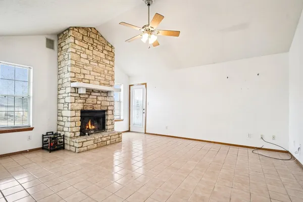 an empty room with windows dryer and fireplace