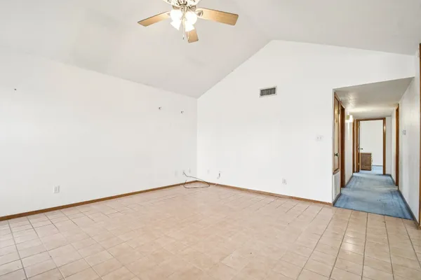 an empty room with chandelier fan