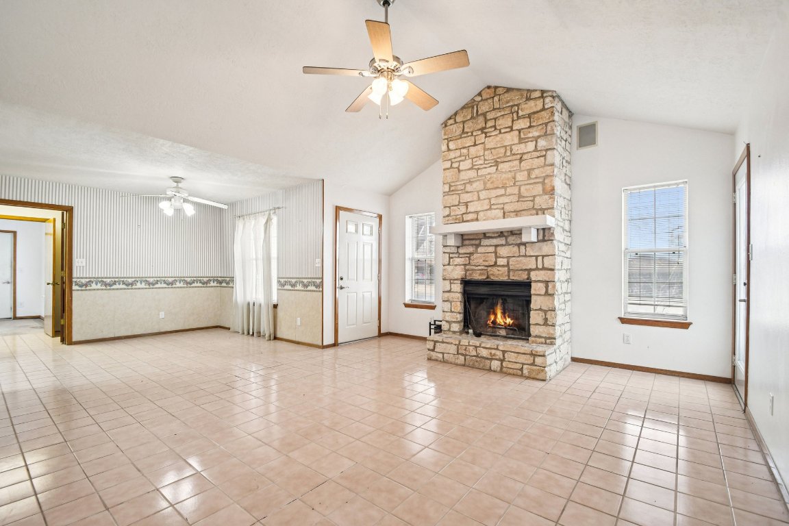 102 Stubblefield Drive Elgin, TX 78621 - Photo 10 of 39 a view of a livingroom with a fireplace a chandelier and windows